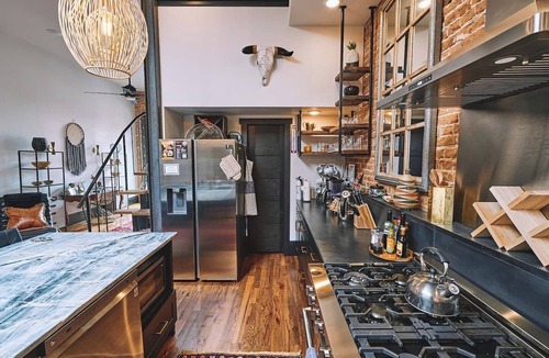 Sheridan Apartment | Luxurious industrial-chic loft in historic downtown Sheridan. This stunning 2-bedroom, 2-bath apartment sleeps up to 9, featuring 2 king suites, 2 1/2 bathrooms sleeping alcove, modern kitchen, fireplace, & Main Street balcony views.