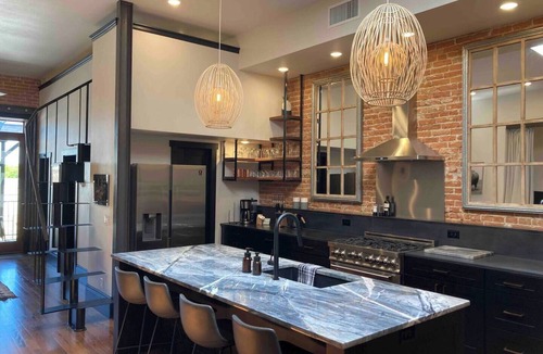 Sheridan Apartment | Luxurious industrial-chic loft in historic downtown Sheridan. This stunning 2-bedroom, 2-bath apartment sleeps up to 9, featuring 2 king suites, 2 1/2 bathrooms sleeping alcove, modern kitchen, fireplace, & Main Street balcony views.